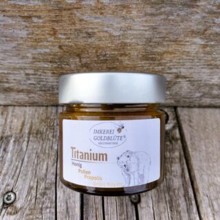 Ein Glas Titanium vor Bienenkasten- der Honig mit Blütenpollen, Propolis und Gelee Royale